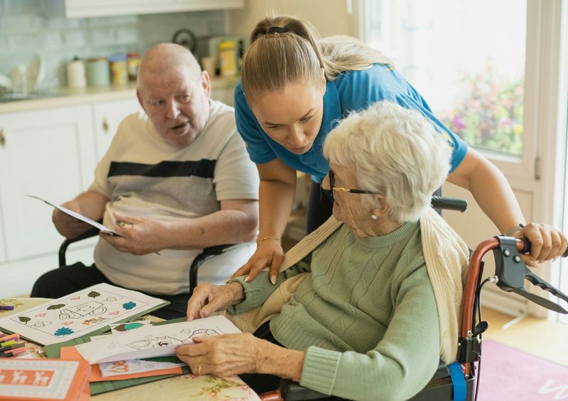 A Golden Touch caregiver sharing an activity with a senior couple at home
