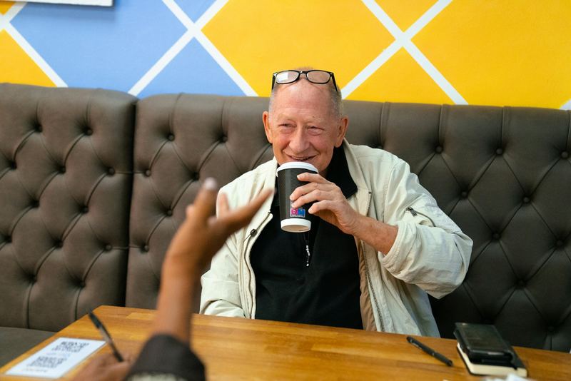 An older woman holding a warm cup in both hands