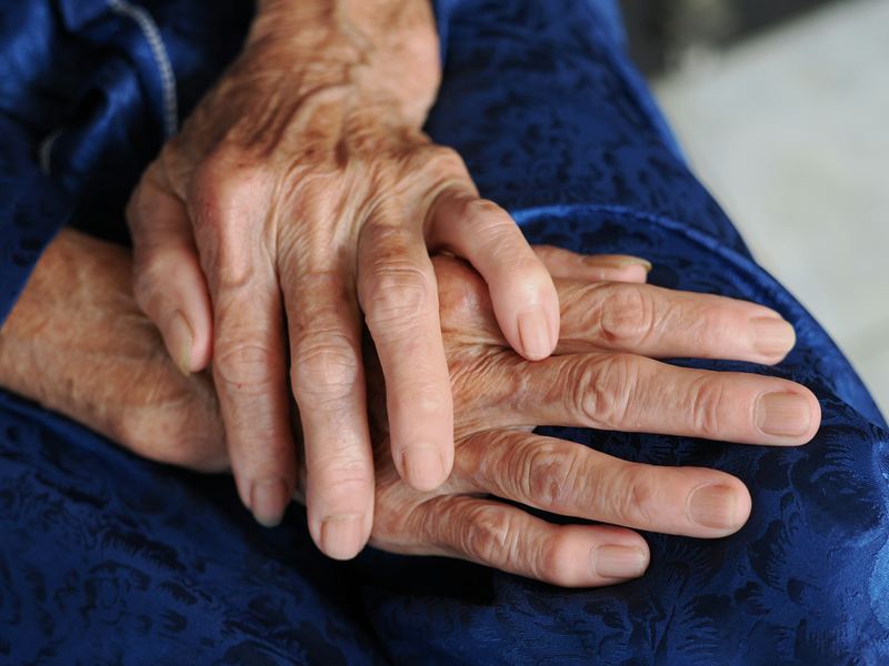 A pair of hands resting quietly in a lap